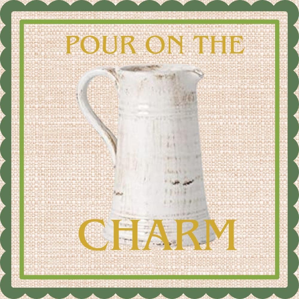 Distressed white faux-ironstone pitcher on linen with a green scalloped border